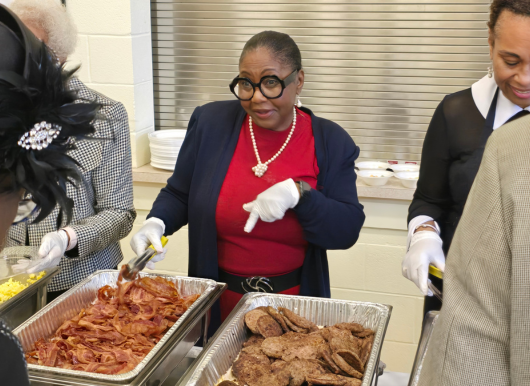 woman serving food while smiling